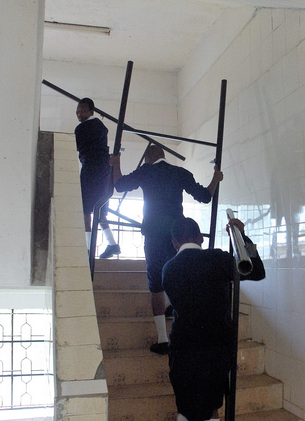 Girls carry bed frames to dorms