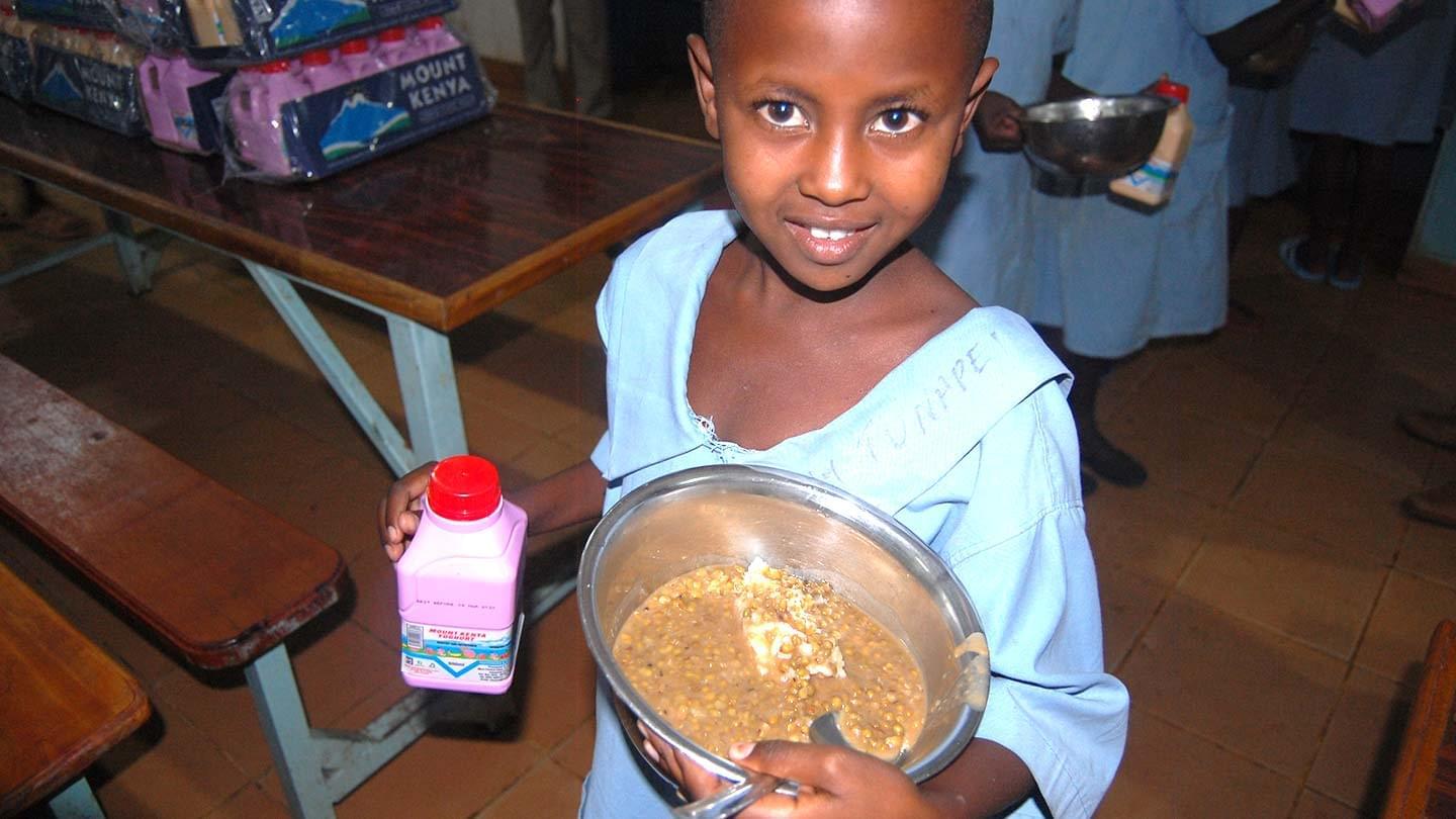 Young girl holding her food bowl and drink