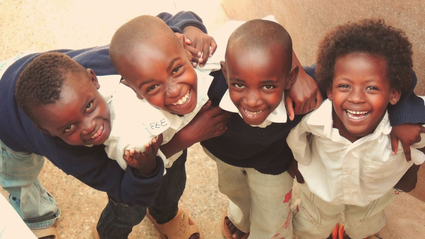 Four children embracing and smiling